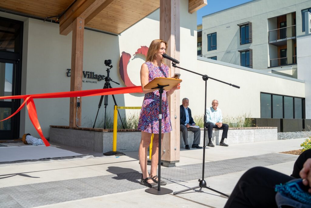 Woman giving speech next to entrance