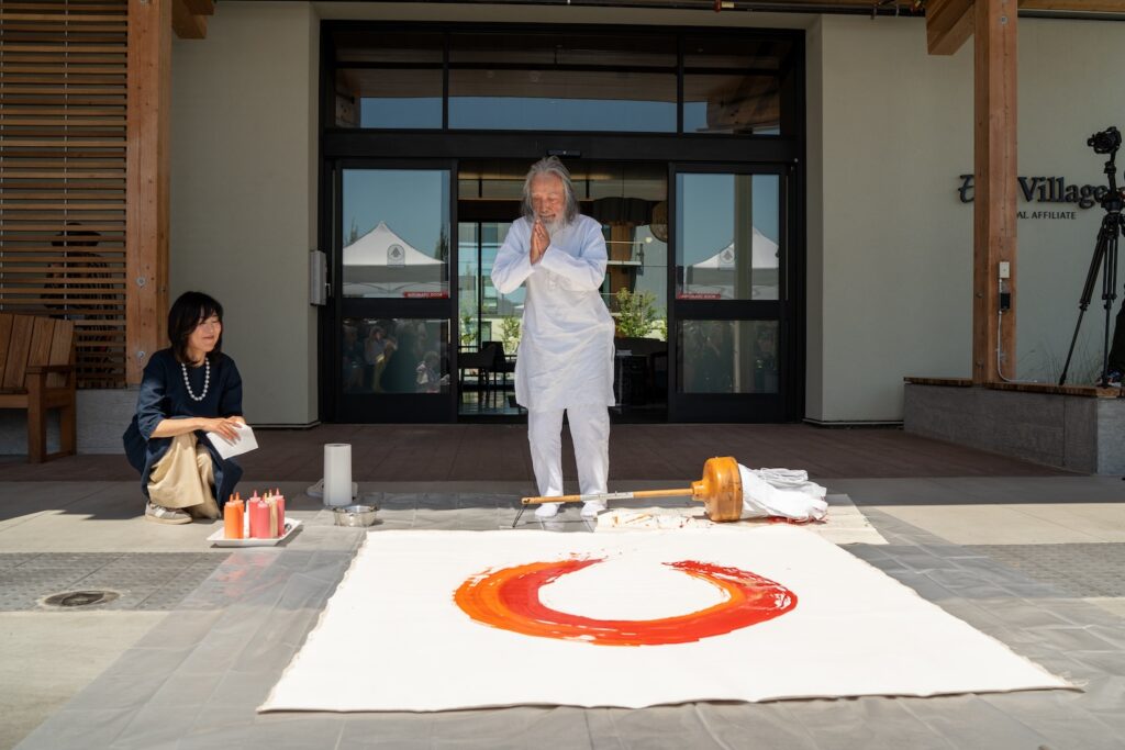 Artists bows over his painting