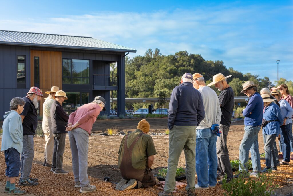 Kitchen Garden Manager, Aris Curtis, holds a brief meeting before planting the garden