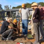 Kitchen Garden Manager, Aris Curtis, shows residents a proper planting technique